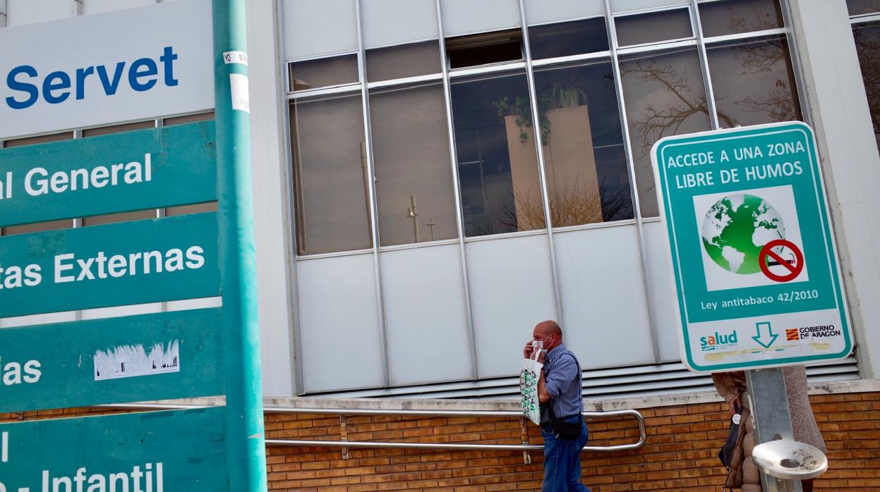 Un hombre se coloca una mascarilla al entrar en el Hospital Miguel Servet de Zaragoza