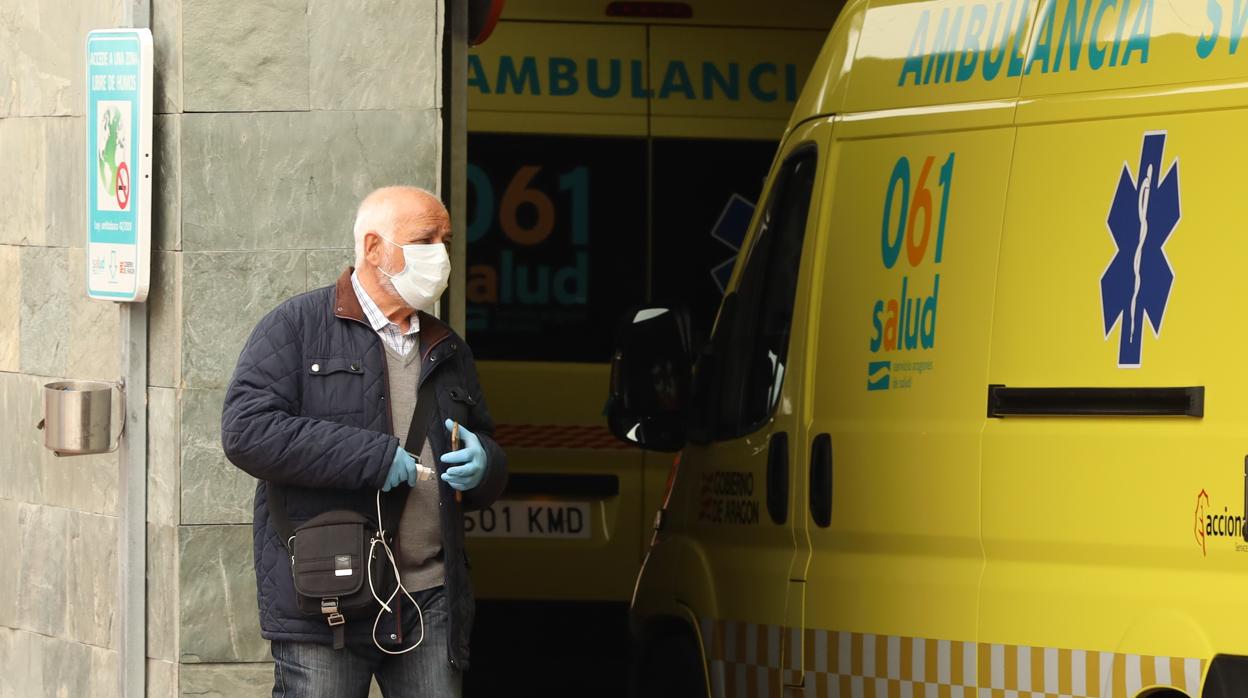 Un hombre se protege con mascarilla y guantes a las puertas de un hospital de Zaragoza