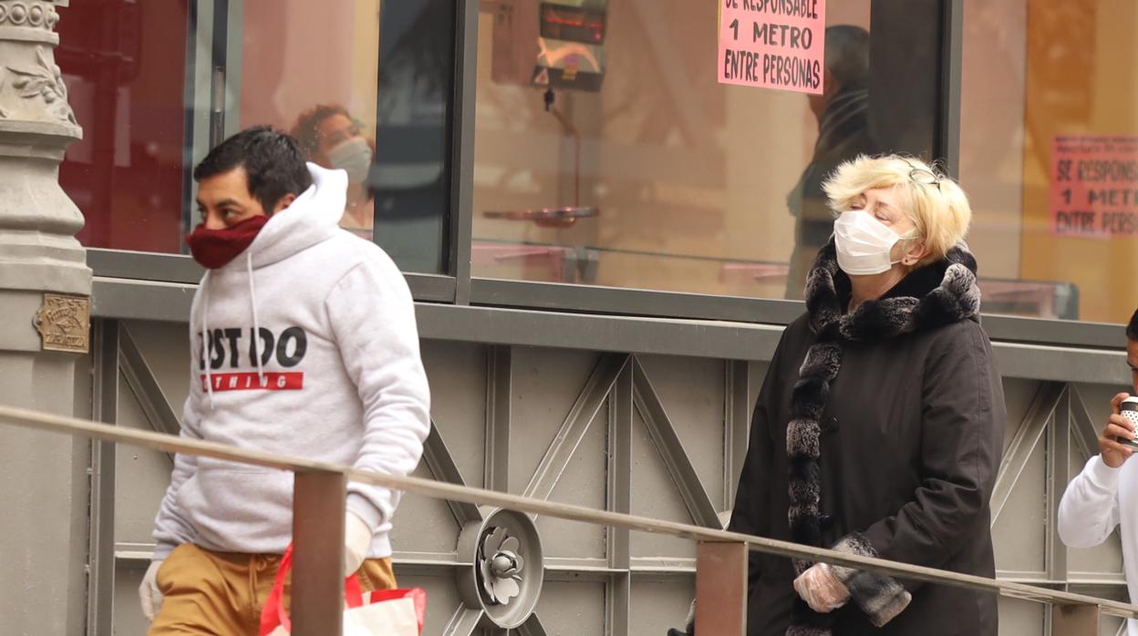 Peatones, junto al Mercado Central de Zaragoza, con la cara cubierta para evitar contagios