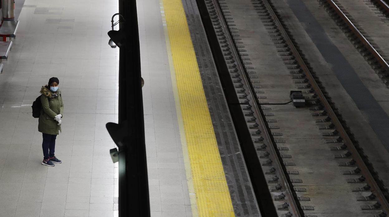 Una usuaria espera la llegada de un tren de Cercanías en la estación de Nuevos Ministerios, en Madrid