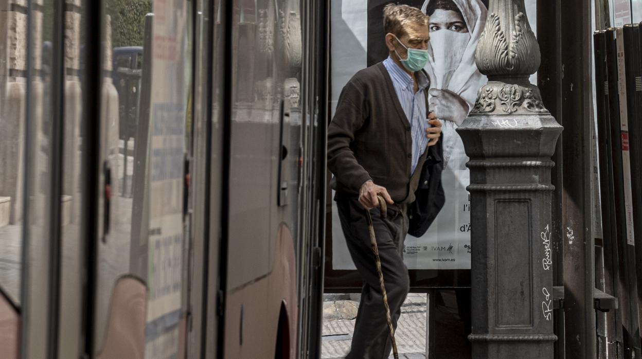 Imagen de un hombre con mascarilla caminando por la calle