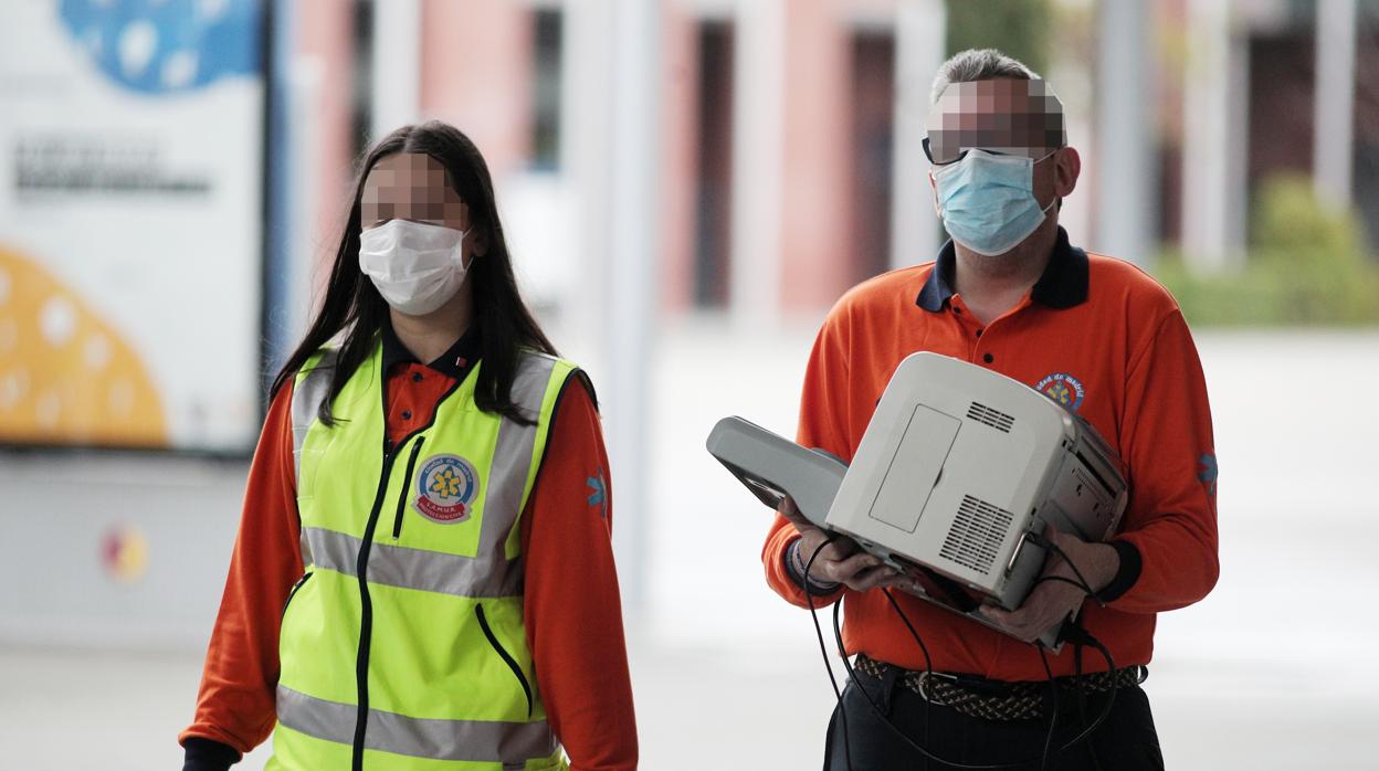 Dos trabajadores del Samur,-Protección Civil, protegidos con mascarillas