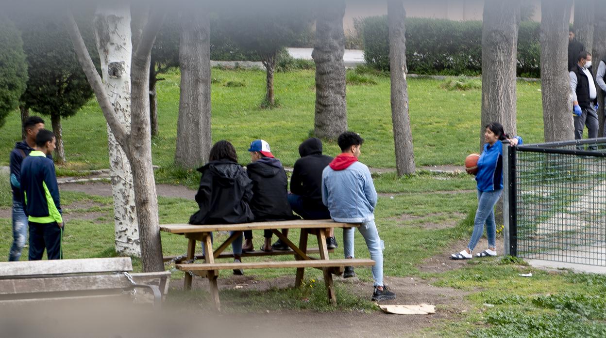 Varios menores pasan el tiempo en el patio del centro, bajo la supervisión de dos trabajadores