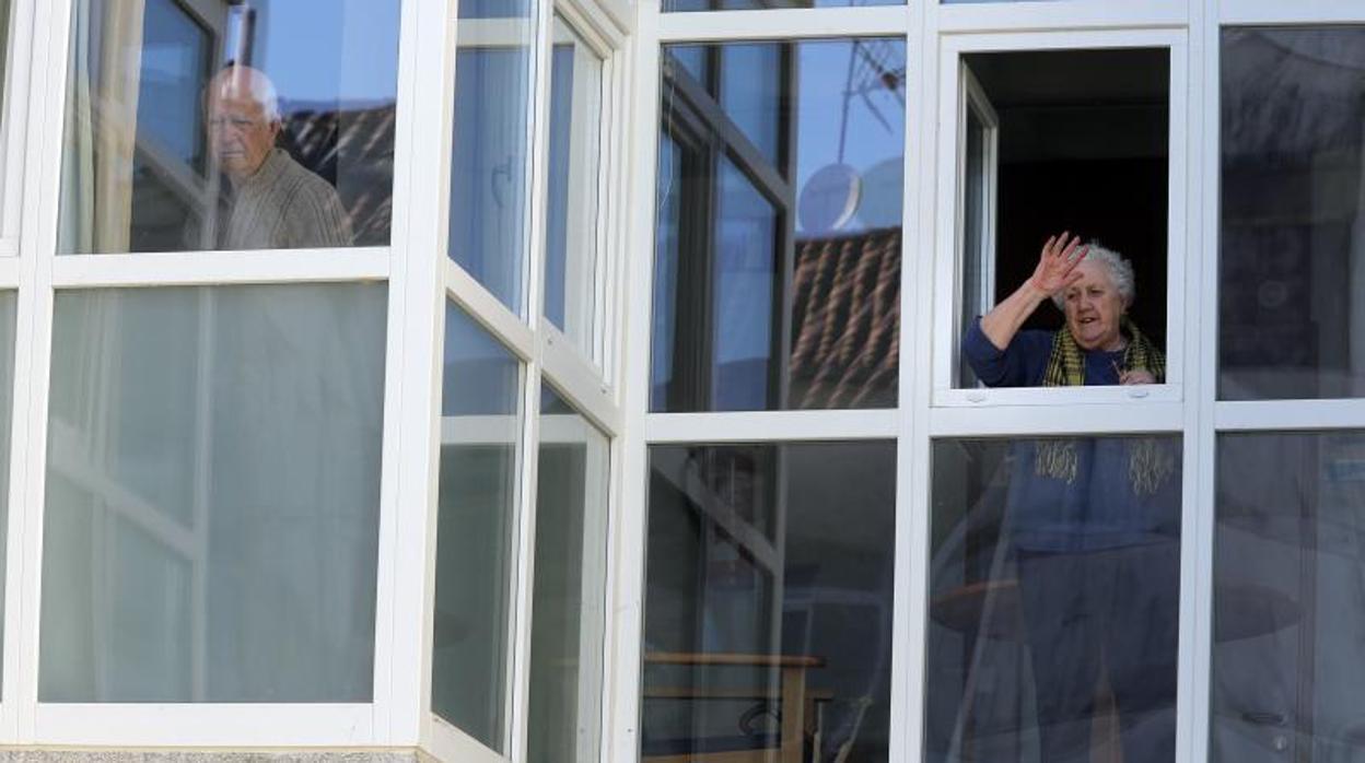 Dos ancianos se asoman a las ventanas de la residencia «Puerta del Camino», en Santiago