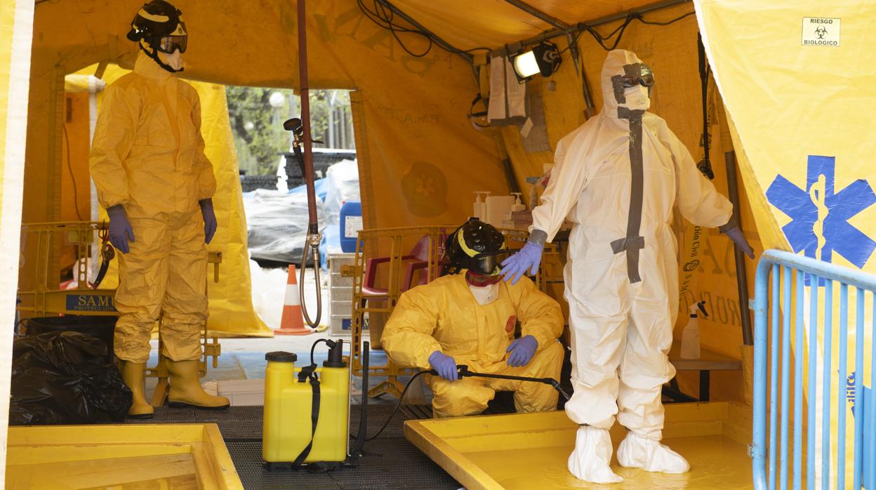 Dos especialistas limpian con lejía y agua a una sanitaria del Samur tras acudir a la casa de un afectado por Covid-19