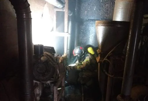 Un bombero, en la zona donde se ha originado el fuego en esta fábrica de harinas de Tauste
