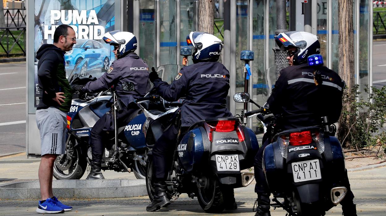 La Policía Nacional para a un ciudadano en el paseo del Prado, Madrid