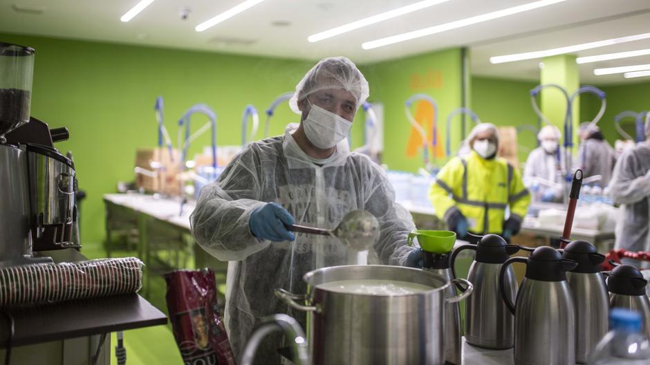 Voluntarios preparan y reparten comida caliente a 800 transportistas al día en Mercamadrid