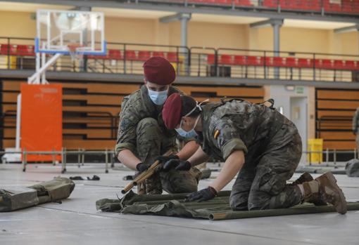 Imagen de dos militaren en pleno proceso de montaje del albergue