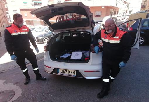 Dos voluntarios (Luis Miguel Álvarez, a la derecha), durante el reparto de la comida a escolares