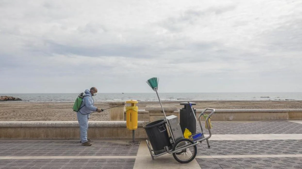 Un operario de limpieza trabaja en una playa de Valencia