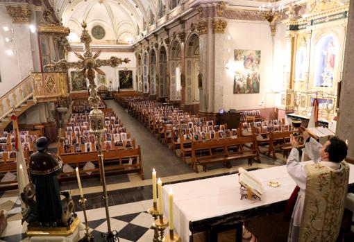 Imagen de la parroquia de Villar del Arzobispo con las fotografías de sus fieles en los bancos de la iglesia