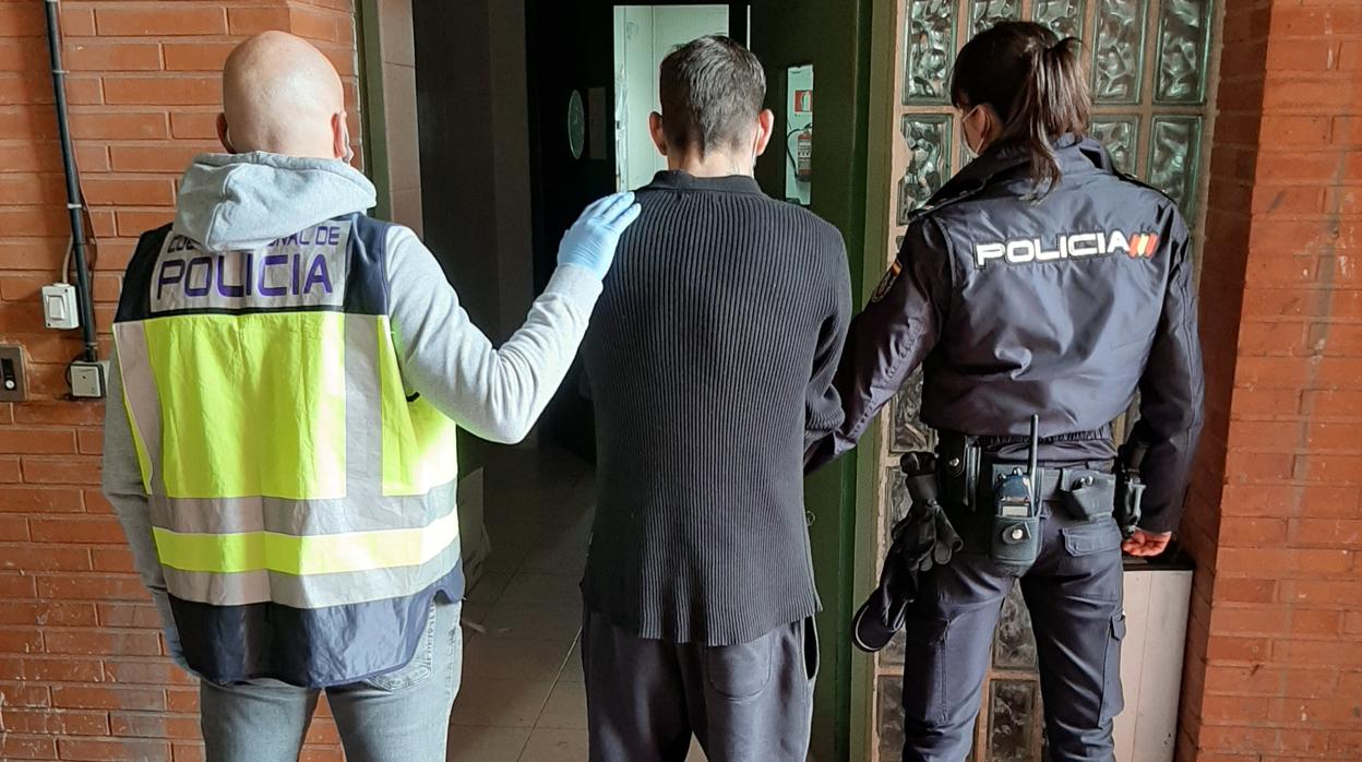 El ladrón detenido en Elche, custodiado por dos agentes de la Policía Nacional de Elche