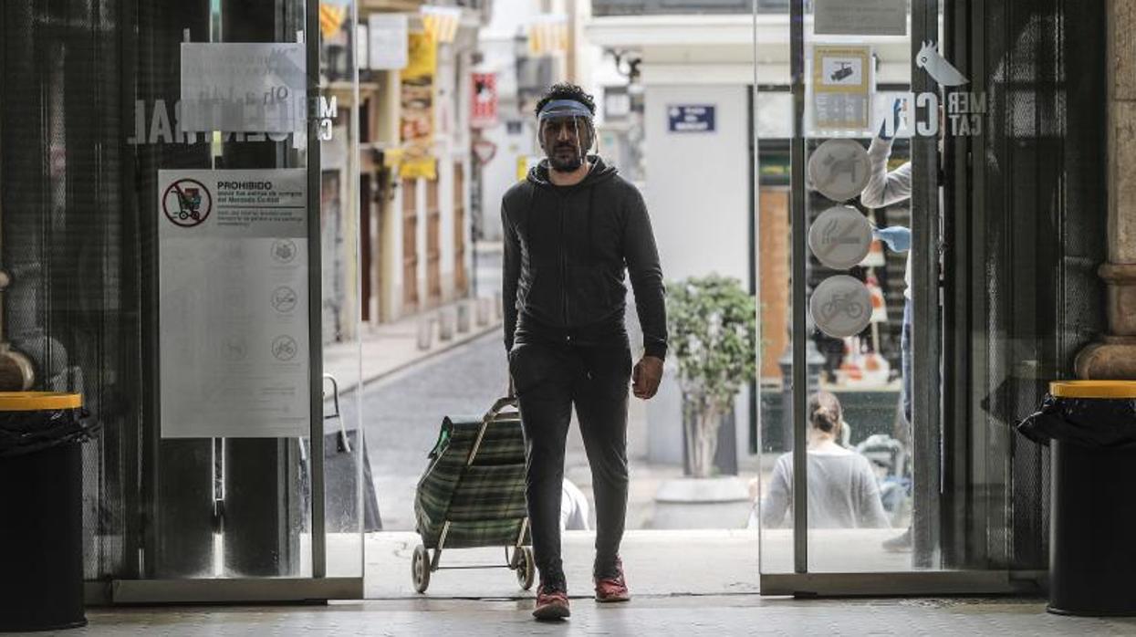 Un consumidor con pantalla protectora en el Mercado de Valencia