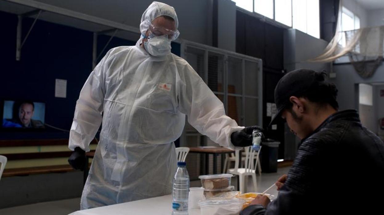 Un trabajador de la asociación Aixiña atiende a un hombre sin hogar en Orense