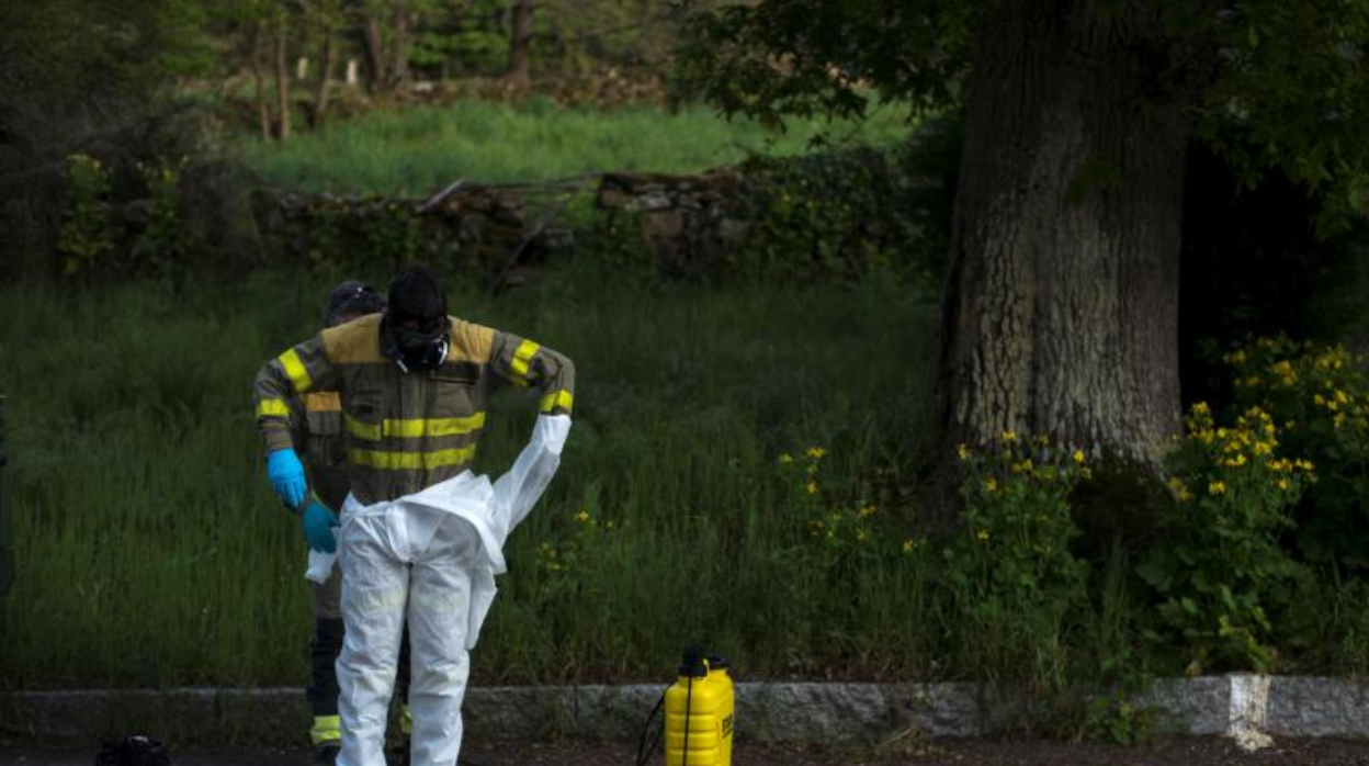 Un voluntario del servicio de prevención y defensa contra los incendios forestales se quita el traje de protección