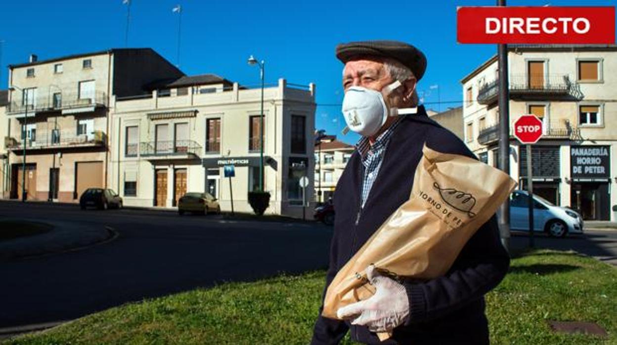 Un hombre viene de comprar el pan protegido con su mascarilla y guantes