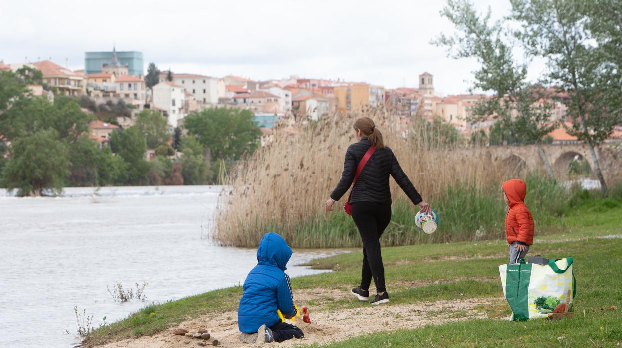 Uma madre juega con sus dos hijos ayer, a orillas del Duero, en la capital zamorana