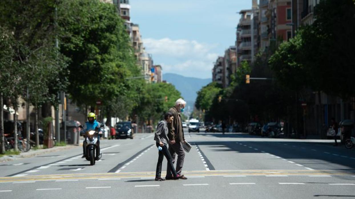 Dos peatones, paseando ayer por Barcelona