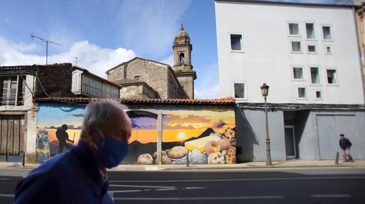 Un hombre, con mascarilla, camina por una calle gallega