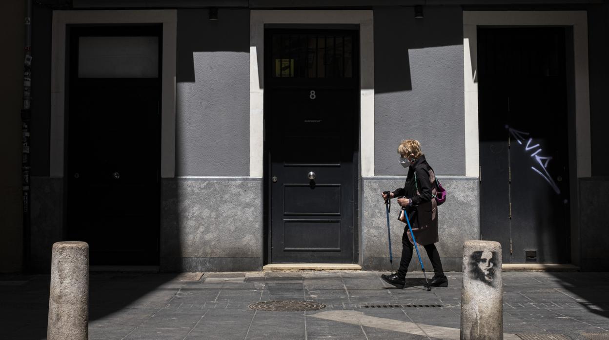 Imagen de una mujer paseando por Valencia con mascarilla