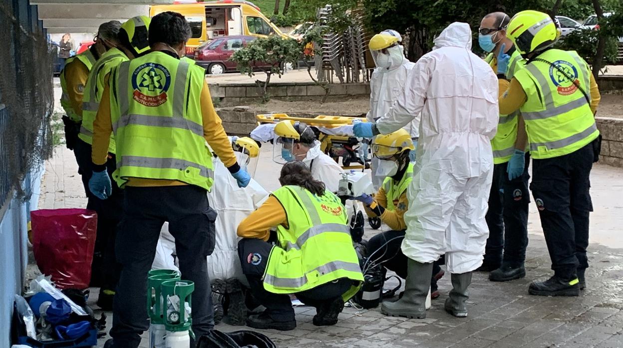 Los servicios médicos atienden a un afectado tras el incendio desatado en una vivienda de Villaverde