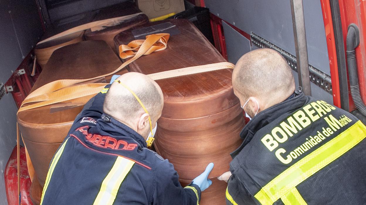 Dos bomberos trasladan un ataúd a una morgue en las semanas de mayor incidencia del coronavirus