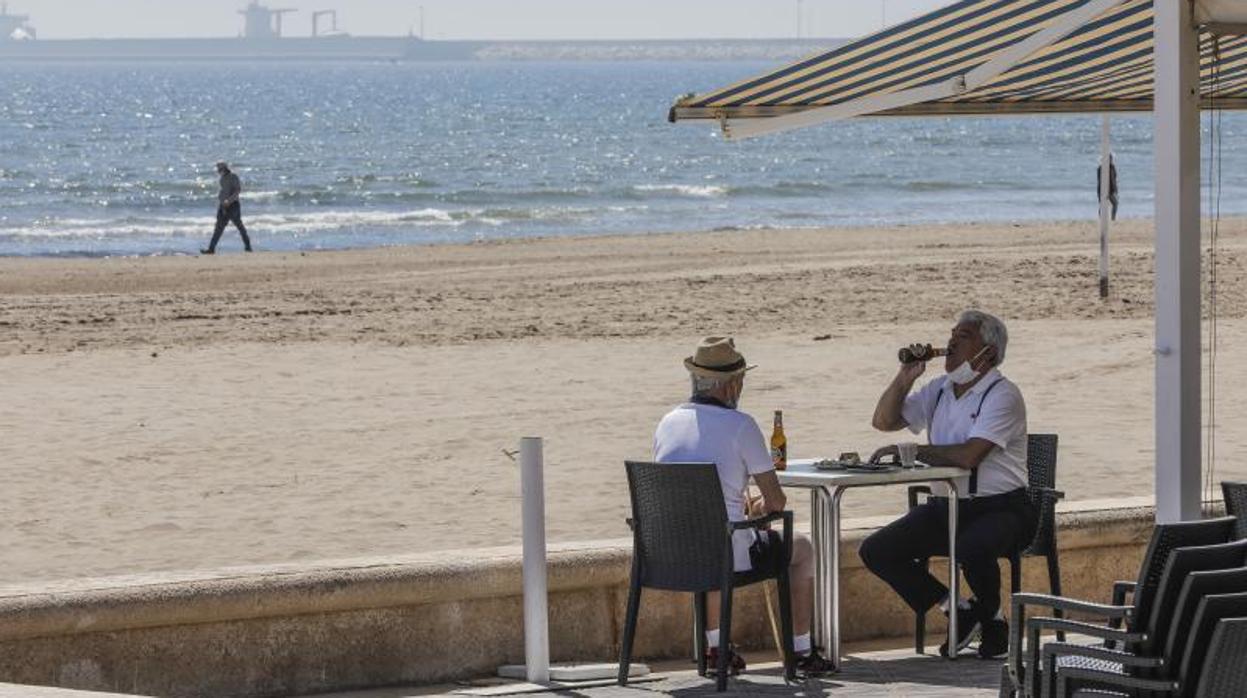 Dos clientes en una terraza junto a la playa en Valencia