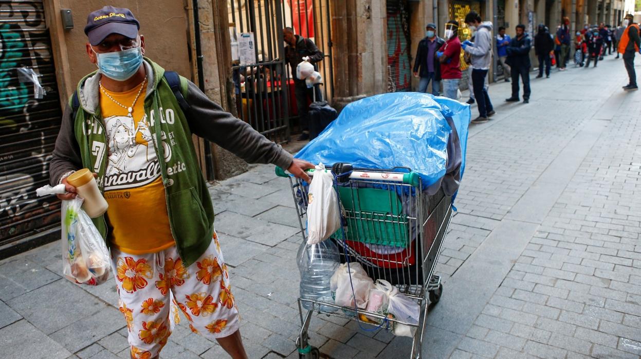 Una persona tras recoger una bolsa de comida en la parroquia de Santa Anna de Barcelona, donde cada día reparten comida para más de 200 personas