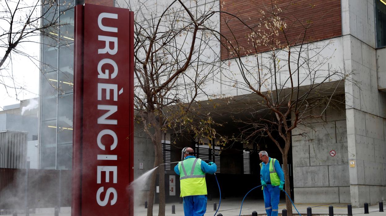 Trabajadores de la limpieza realizan su tarea en la entrada de urgencias del Hospital de Bellvitge