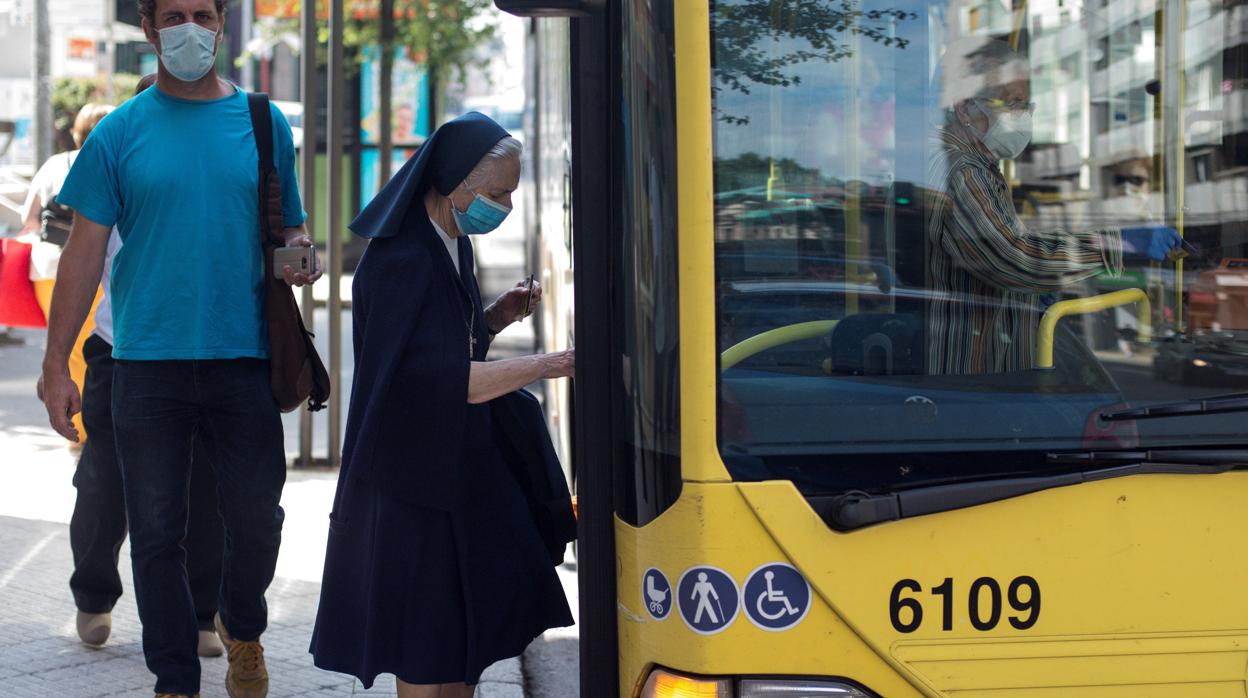 Una monja con mascarilla se monta en un autobús urbano, este martes en Orense