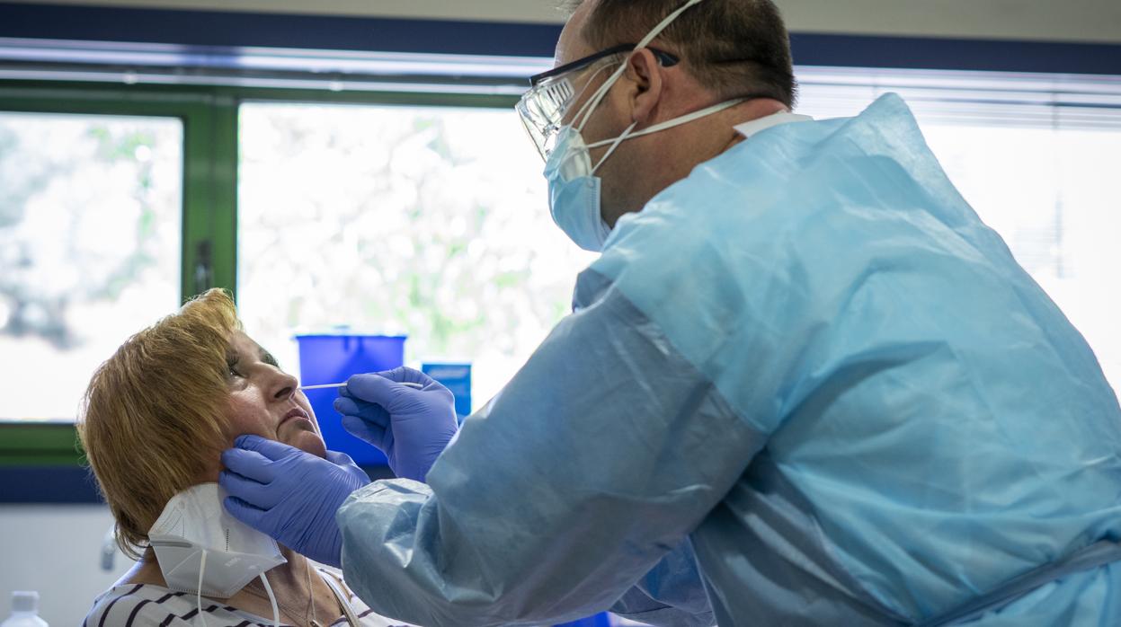 Un sanitario de Atención Primaria realiza una PCR a una mujer en un centro de salud de Madrid