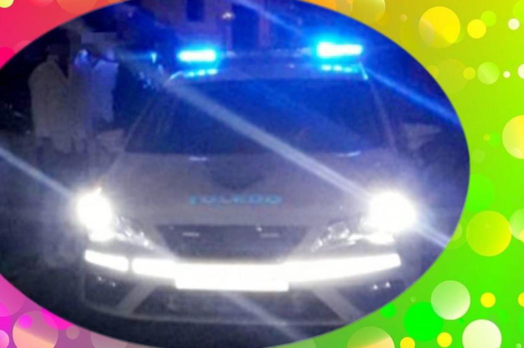 Algunos jóvenes junto a un coche policial en el desalojo