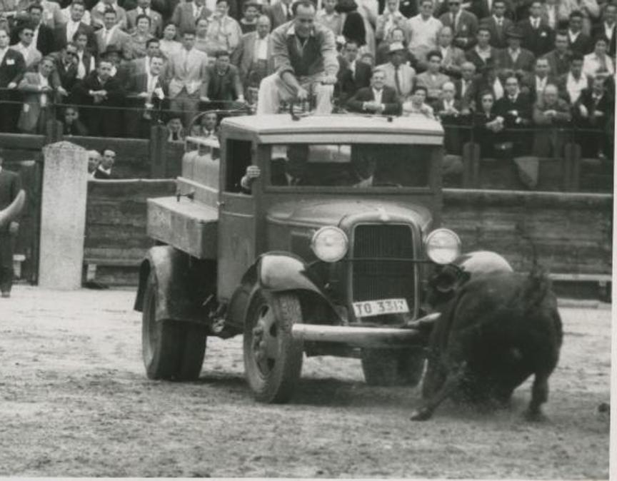 La imagen es del Corpus de 1958, celebrado el día 5 de junio, cuando el cuarto toro de la ganadería del Conde de la Corte, manso de solemnidad, se negó a abandonar el ruedo y hubo que tirar de ingenio para que volviera a los corrales. Eso incluyó un camión, que sirvió de ayuda a los bueyes y al que embistió el astado. Julio Aparicio, Antonio Ordóñez y Gregorio Sánchez formaron el cartel