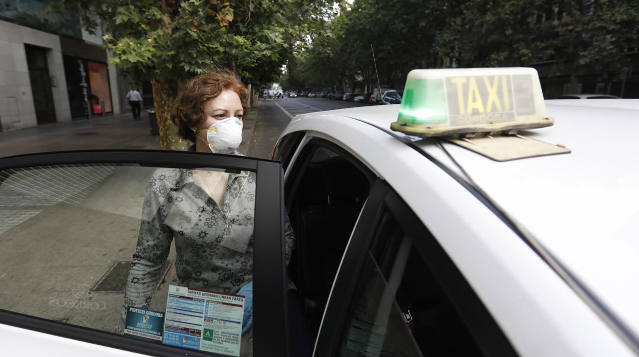 Una usuaria se sube a un taxi con las mascarilla