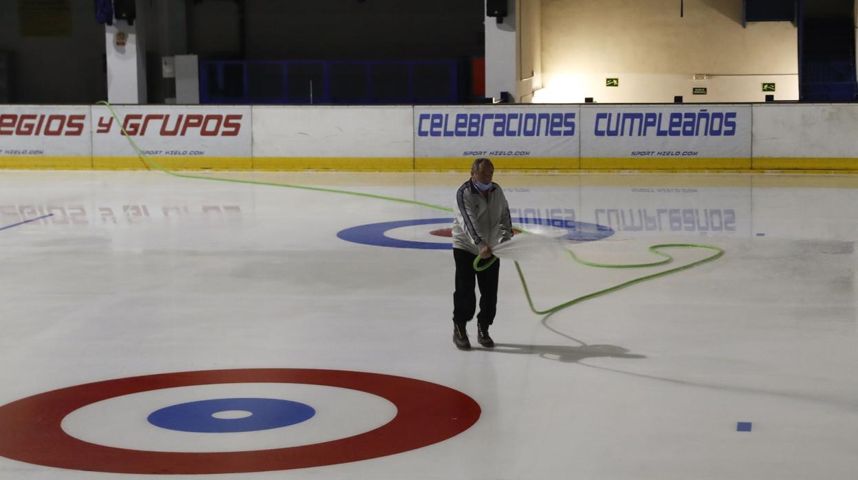 Un empleado acondiciona la pista de patinaje, todavía cerrada, del Palacio de Hielo