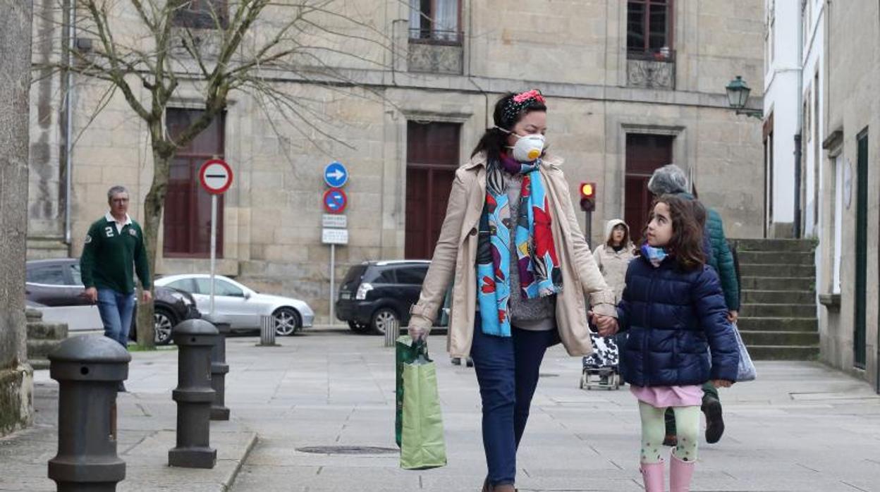 Una mujer, con mascarilla, junto a una menor en Santiago