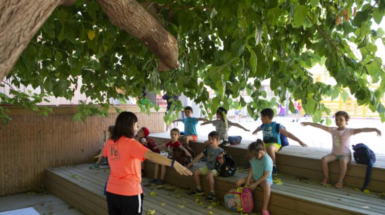 Una monitora de «casal» de verano de la escuela Joan Miró de Barcelona, hablando de las distancias de seguridad con un grupo de niños