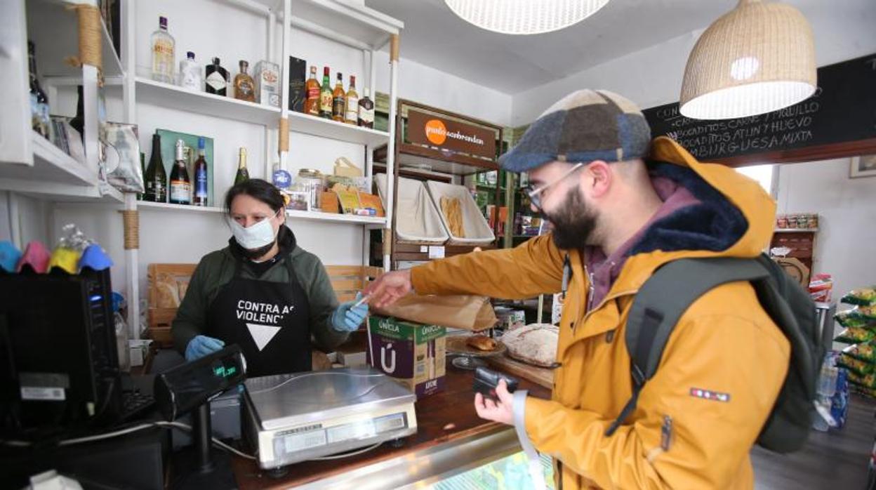 Un hombre compra en una tienda de Santiago durante la pandemia de coronavirus