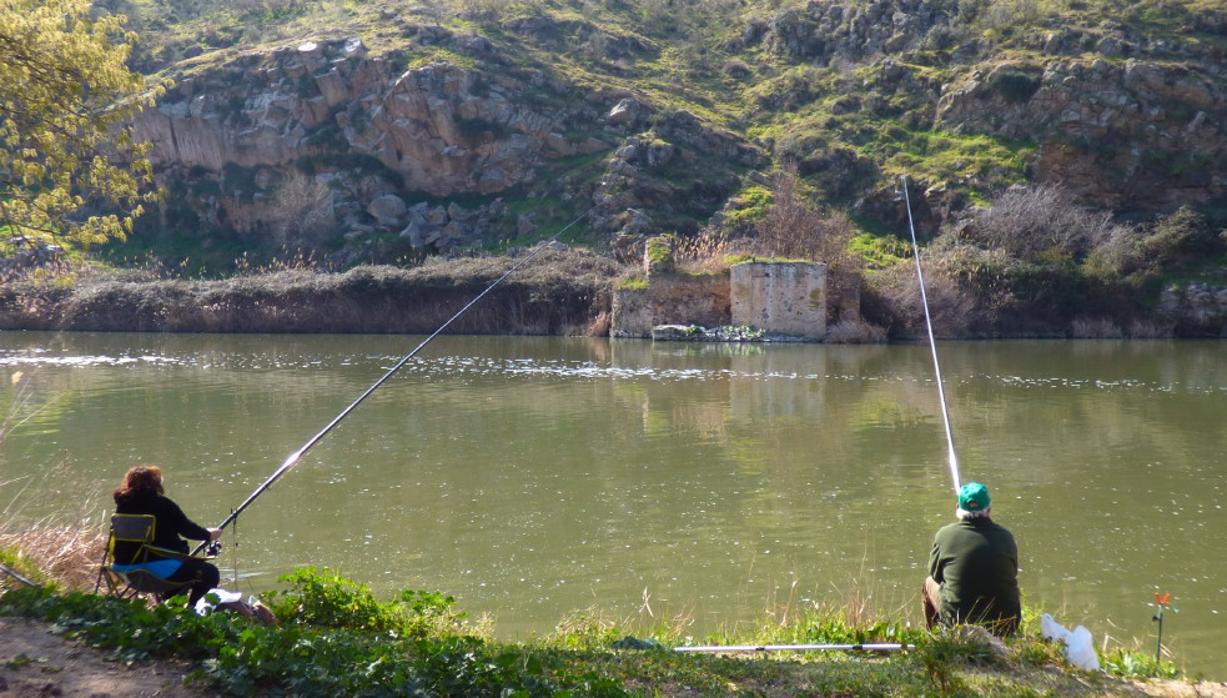 Pescadores en la orilla derecha del río en 2018. Enfrente, bajo la ladera del Valle, los vestigios de los molinos de la Vieja. FOTO RAFAEL DEL CERRO