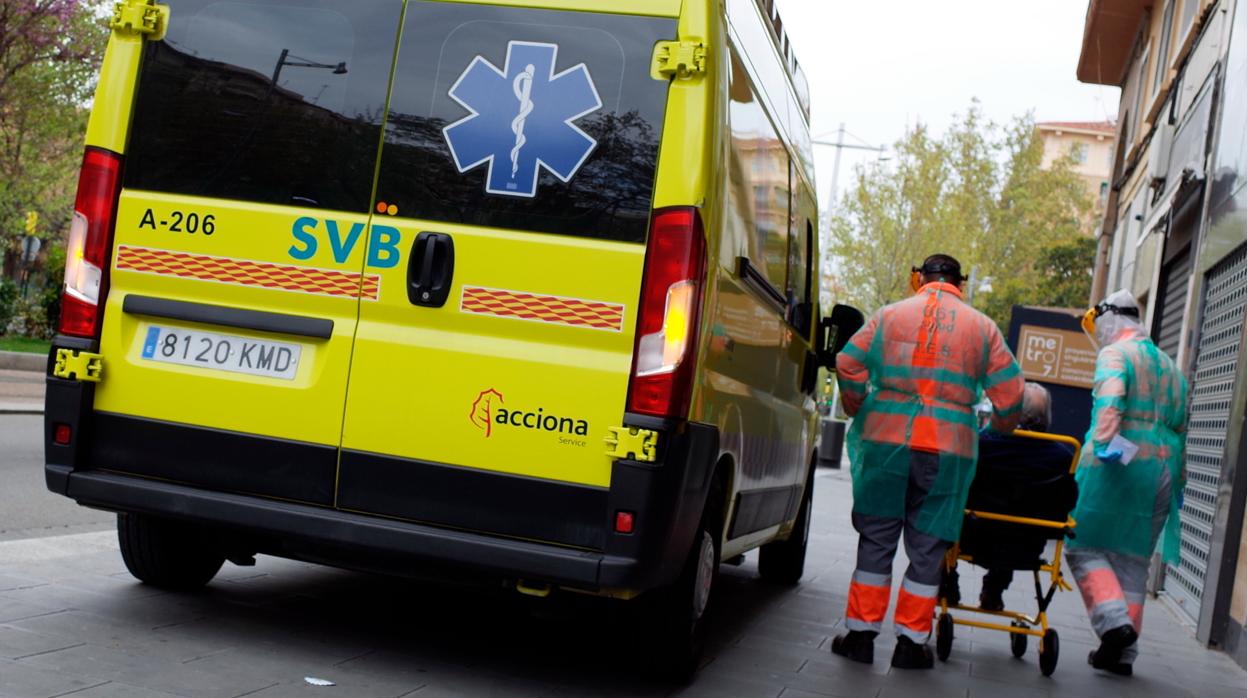 Dos sanitarios se disponen a trasladar a un anciano en ambulancia, en Zaragoza