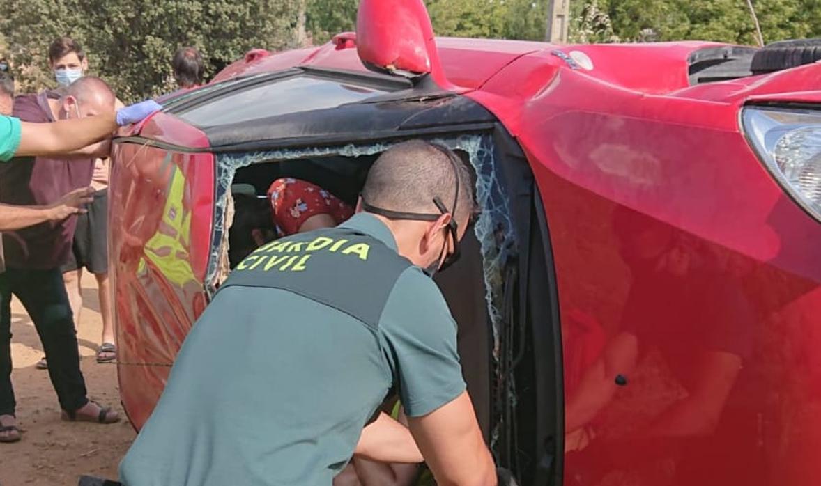 Uno de los agentes de la Guardia Civil pica la luna del vehículo accidentado en la Tabla de la Yedra