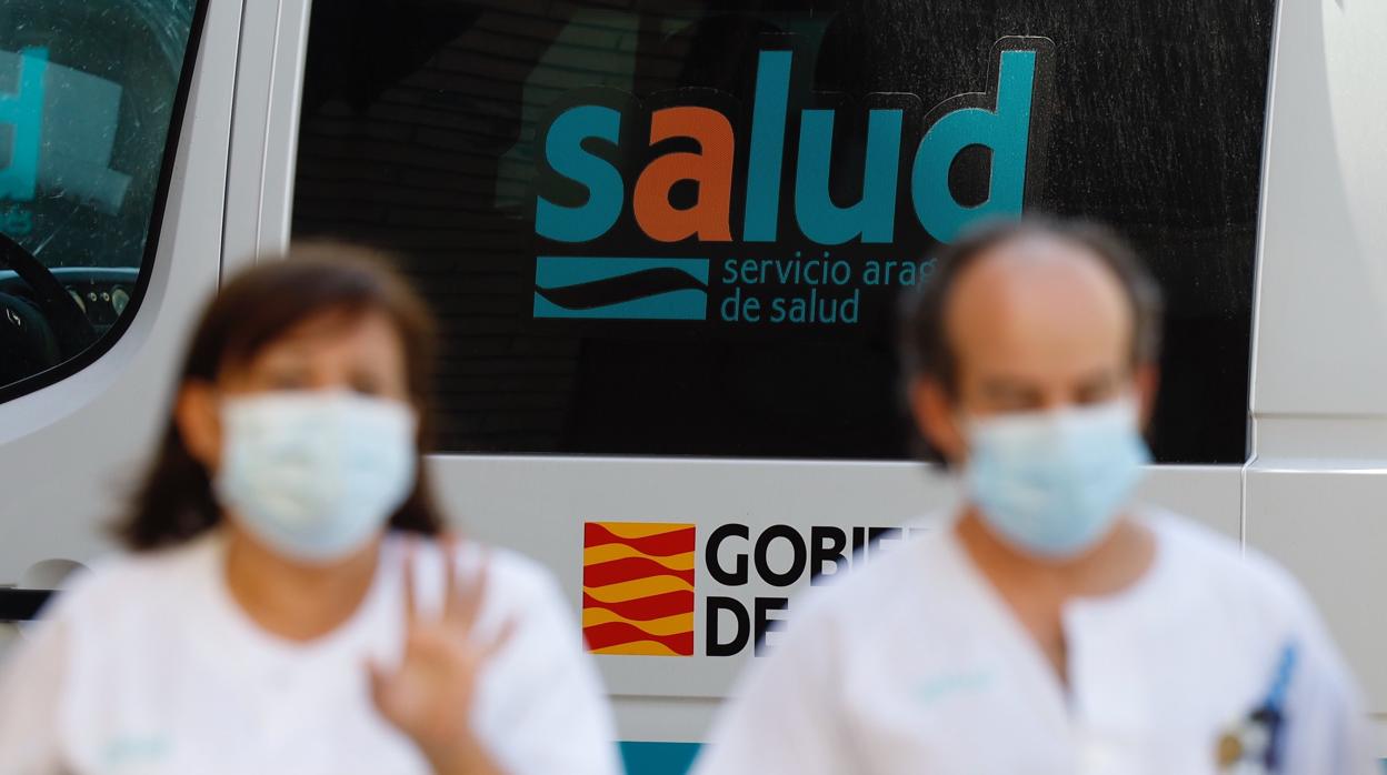 Dos sanitarios con mascarilla, ante una ambulancia del Servicio Aragonés de Salud. Esta región presenta desde hace semanas la mayor tasa de contagios Covid de España