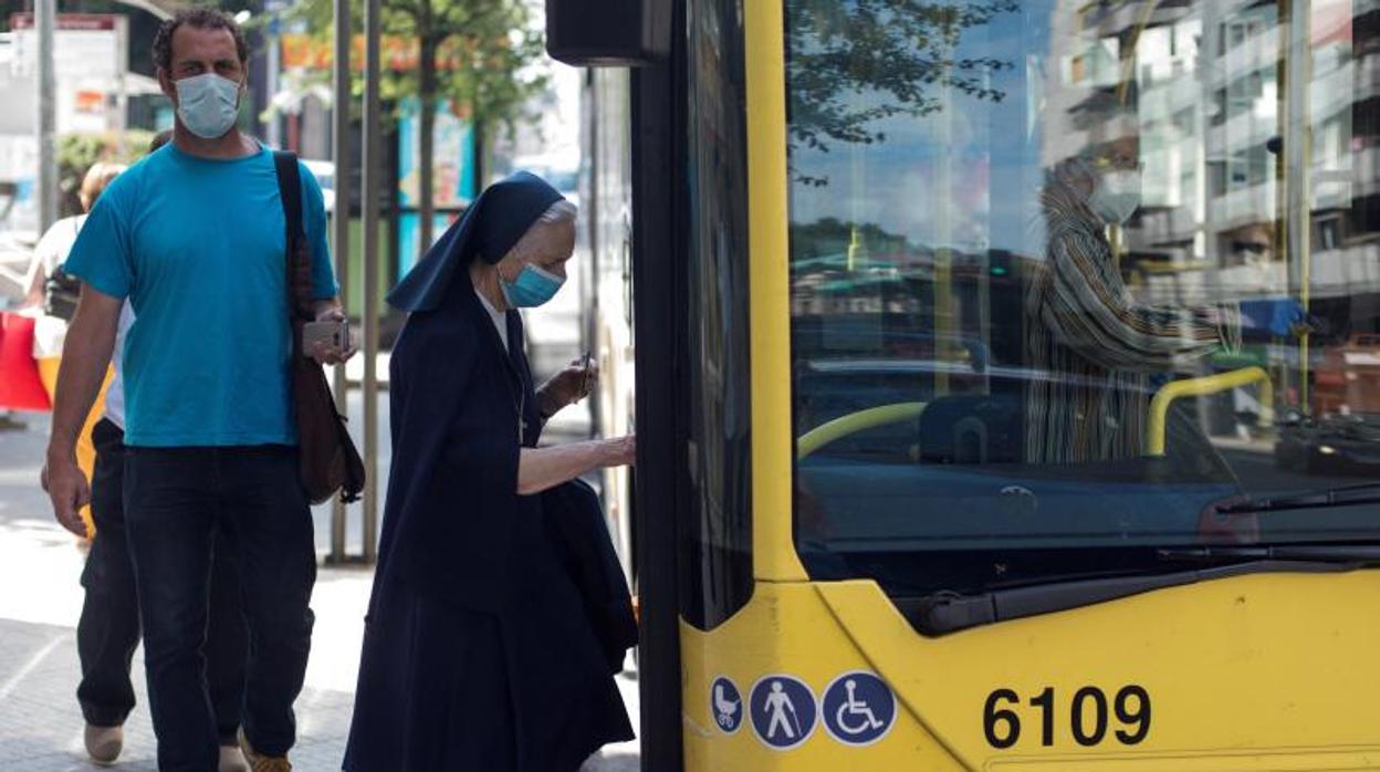 Personas provistas de mascarilla acceden a un autobús en Galicia