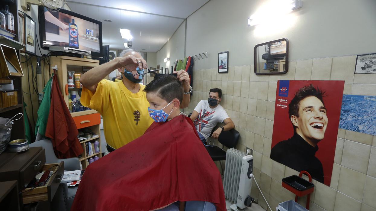 Un niño se corta el pelo en una peluquería de Orense el pasado martes