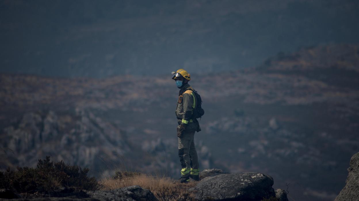 Un brigadista contempla la destrucción en el fuego de Lobios, aún activo