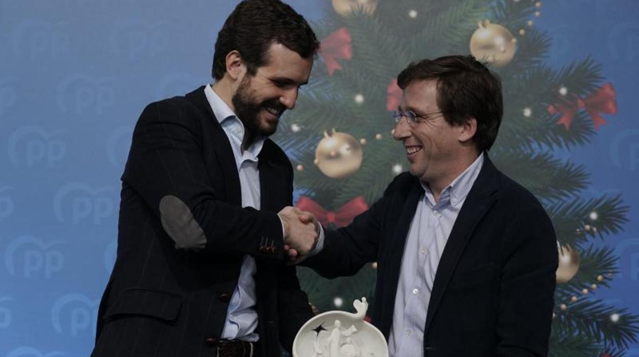 Pablo Casado y José Luis Martínez Almeida se saludan en la comida de Navidad del PP de Madrid, celebrada en un pabellón de la Casa de Campo