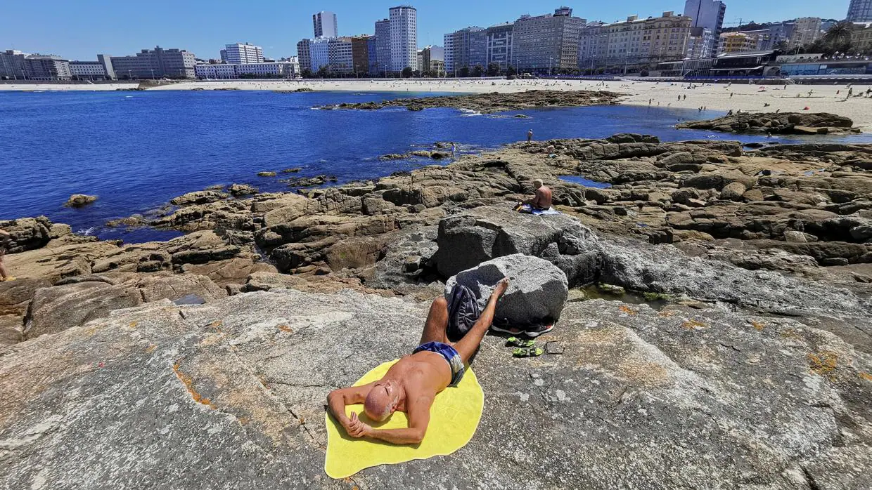 Un bañista disfruta del sol en Riazor, una de las playas afectadas por la presencia de bacterias fecales