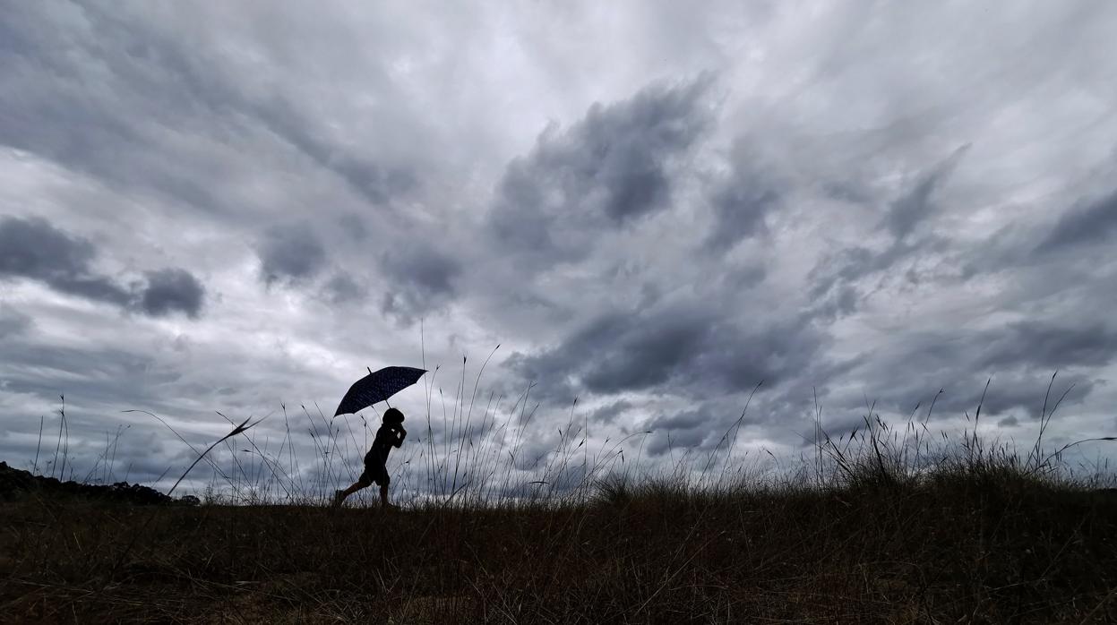 Un niño gallego se protege de las lluvias