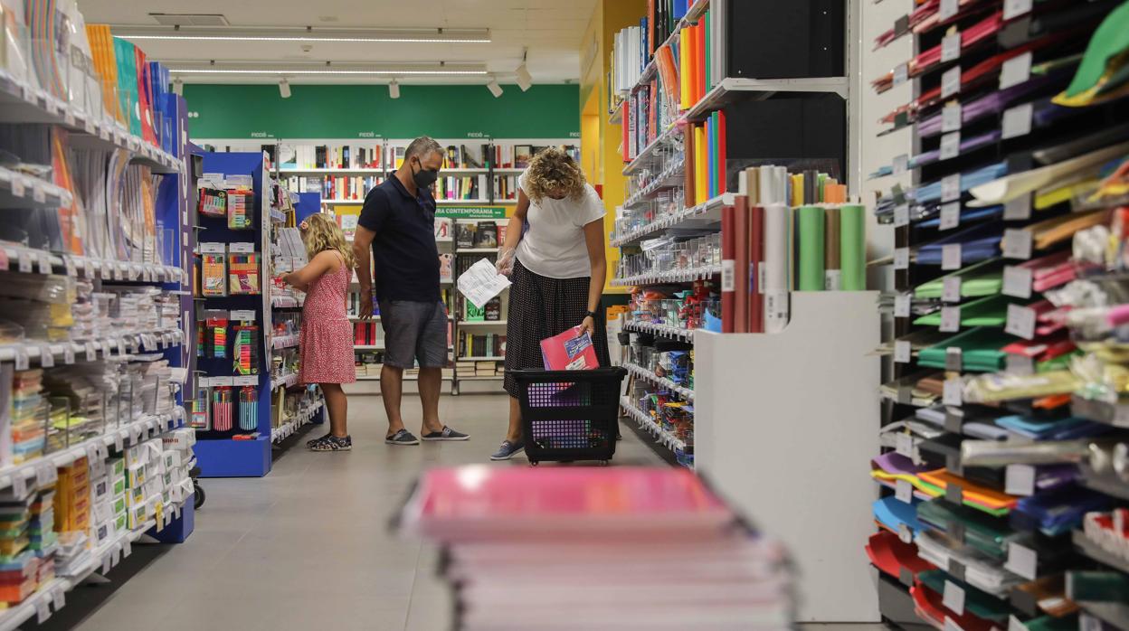 Una pareja compra material escolar para la vuelta al cole en una papelería en Valencia